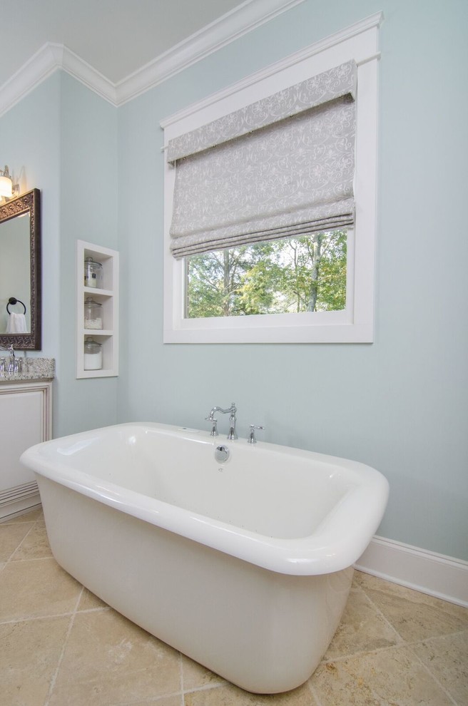 На фото: главная ванная комната среднего размера в классическом стиле с фасадами с выступающей филенкой, белыми фасадами, отдельно стоящей ванной, синими стенами и бежевым полом с