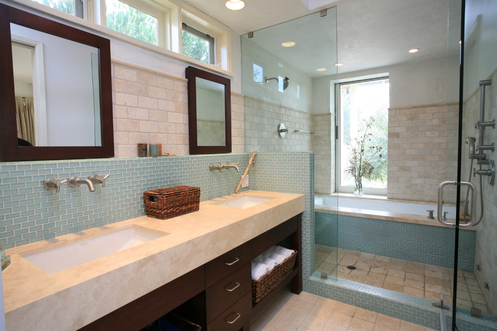 Inredning av ett klassiskt badrum, med ett badkar i en alkov, en dusch/badkar-kombination, blå kakel, beige kakel och travertinkakel