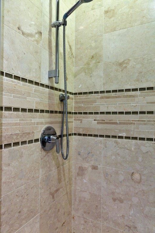 Photo of a medium sized contemporary bathroom in Phoenix with flat-panel cabinets, dark wood cabinets, engineered stone worktops, an alcove shower, a two-piece toilet, beige tiles, stone tiles, beige walls and limestone flooring.