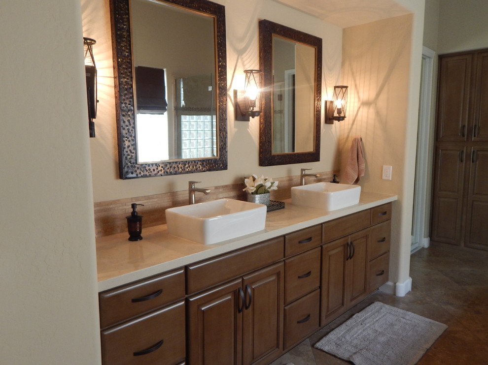 Immagine di una stanza da bagno industriale con ante con bugna sagomata, piastrelle beige, piastrelle in pietra, lavabo a bacinella e top in quarzite