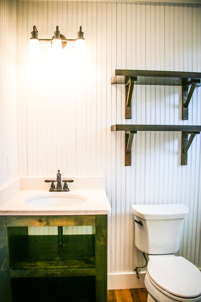 Imagen de cuarto de baño urbano pequeño con armarios abiertos, puertas de armario verdes, paredes blancas, suelo de contrachapado, aseo y ducha, lavabo encastrado, encimera de laminado, suelo marrón y encimeras blancas