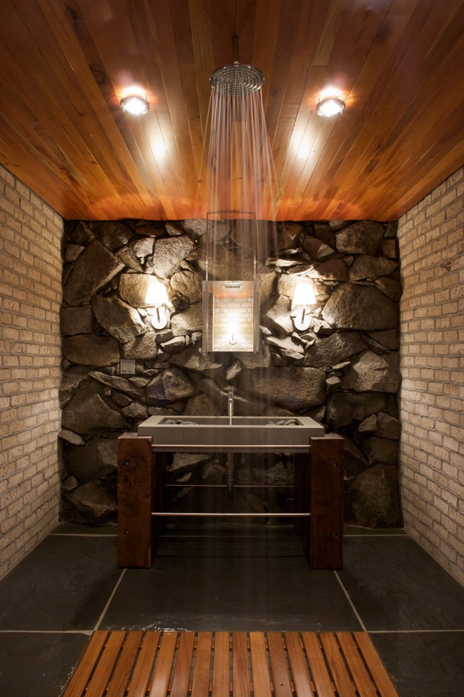 Exemple d'une salle de bain tendance avec un lavabo intégré, une douche ouverte, aucune cabine et un mur en pierre.