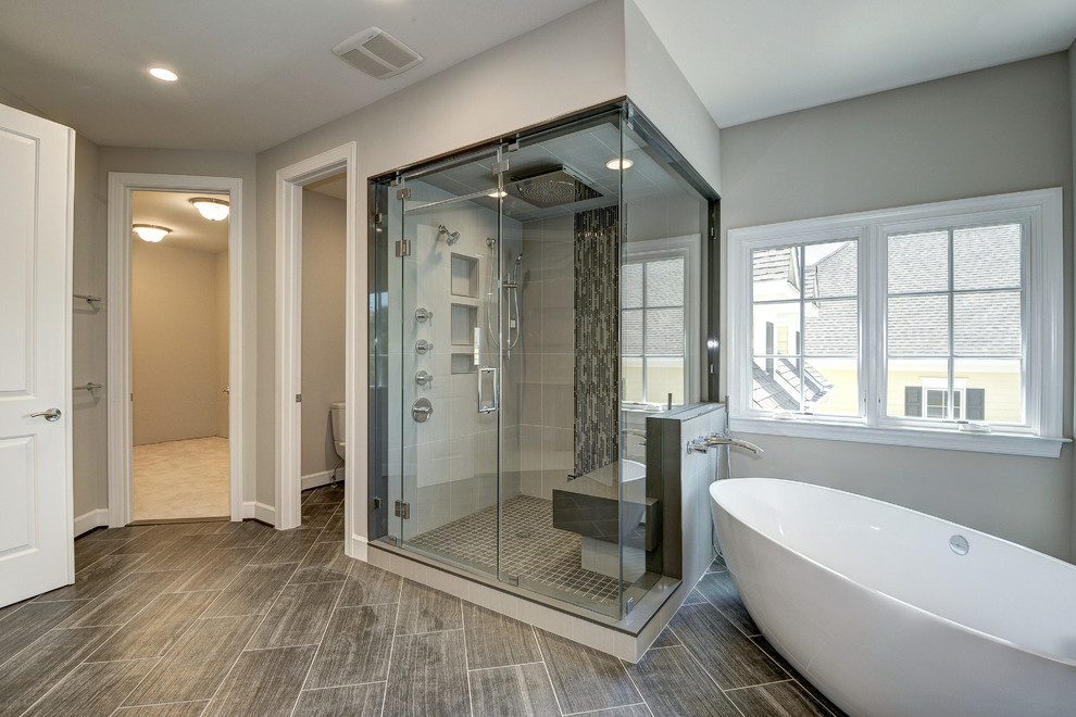 Inspiration för ett stort vintage en-suite badrum, med ett fristående badkar, en hörndusch, beige kakel, svart kakel, grå kakel, stickkakel, grå väggar, klinkergolv i porslin, grått golv och dusch med gångjärnsdörr