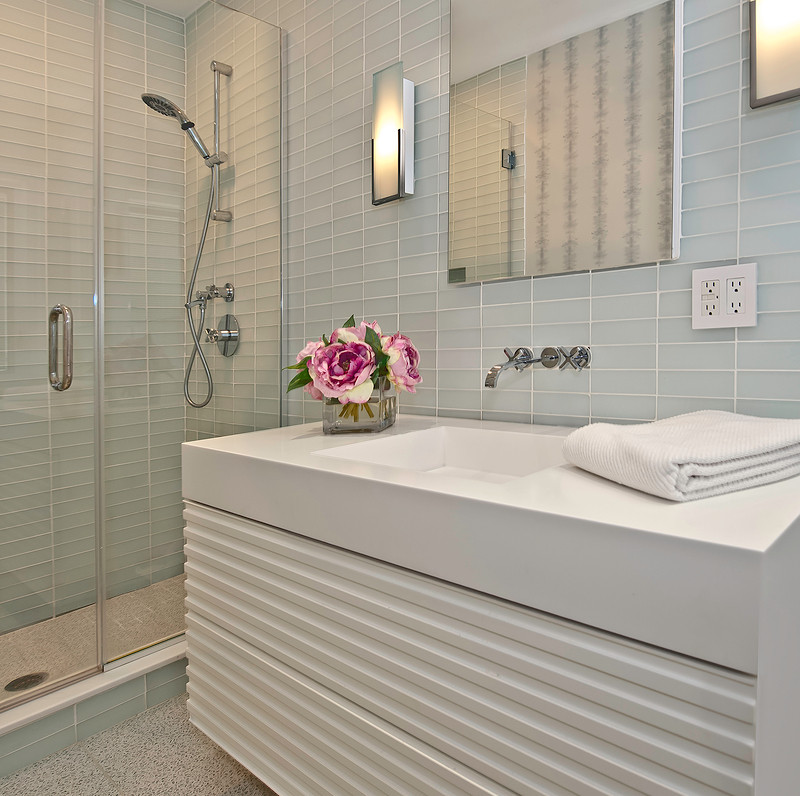 Idéer för ett mellanstort modernt badrum med dusch, med möbel-liknande, vita skåp, en dusch i en alkov, grå kakel, glaskakel, grå väggar, ett integrerad handfat, bänkskiva i kvarts, grått golv och dusch med gångjärnsdörr