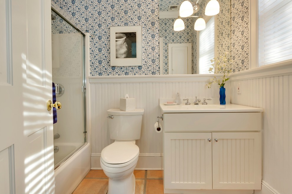 На фото: ванная комната среднего размера в классическом стиле с фасадами с филенкой типа жалюзи, белыми фасадами, ванной в нише, душем над ванной, раздельным унитазом, белыми стенами, душевой кабиной, монолитной раковиной, столешницей из искусственного камня, душем с раздвижными дверями, полом из терракотовой плитки и красным полом с