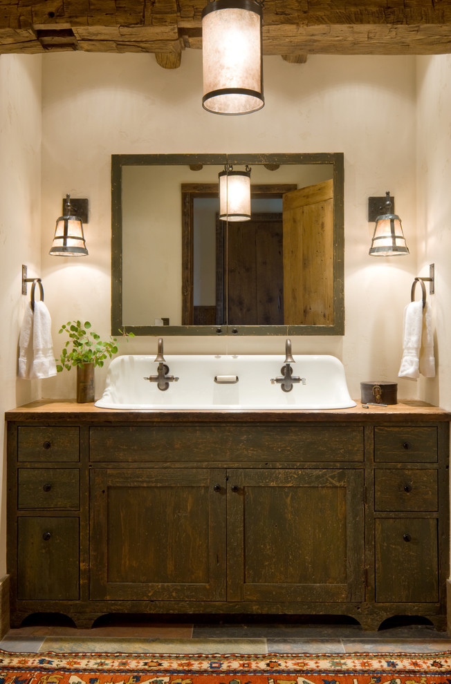 Пример оригинального дизайна: ванная комната в стиле рустика с бежевыми стенами, раковиной с несколькими смесителями, фасадами в стиле шейкер и темными деревянными фасадами