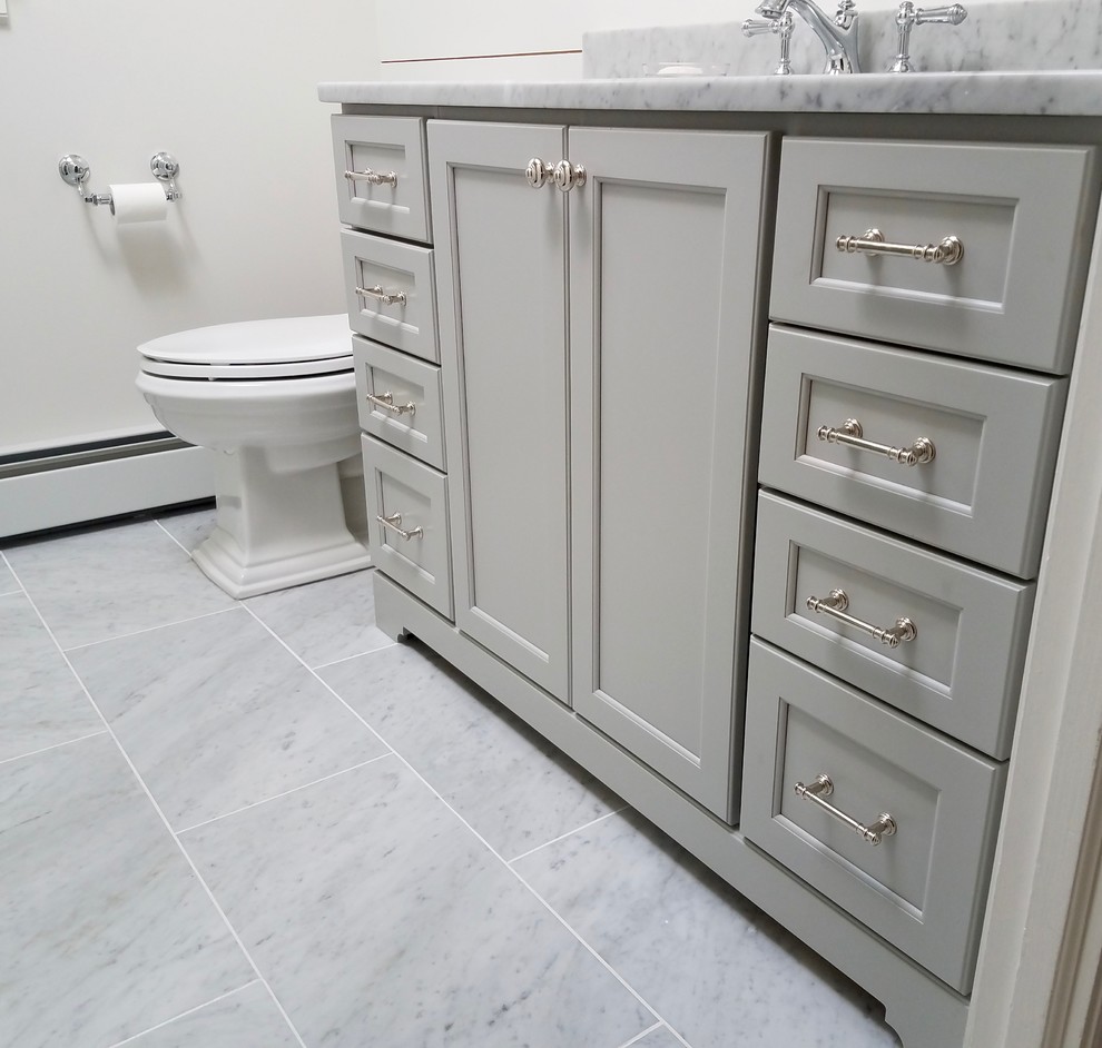 Klassisk inredning av ett mellanstort badrum med dusch, med luckor med infälld panel, grå skåp, en dusch i en alkov, en toalettstol med hel cisternkåpa, vita väggar, marmorgolv, ett undermonterad handfat, marmorbänkskiva, grått golv, dusch med gångjärnsdörr, grå kakel och tunnelbanekakel
