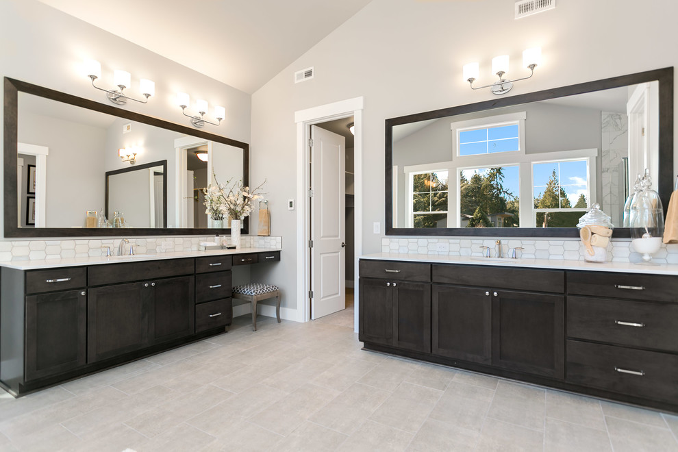Bild på ett stort amerikanskt vit vitt en-suite badrum, med luckor med infälld panel, skåp i mörkt trä, ett fristående badkar, en dusch i en alkov, vit kakel, grå väggar, ett undermonterad handfat, bänkskiva i kvarts, grått golv och dusch med gångjärnsdörr
