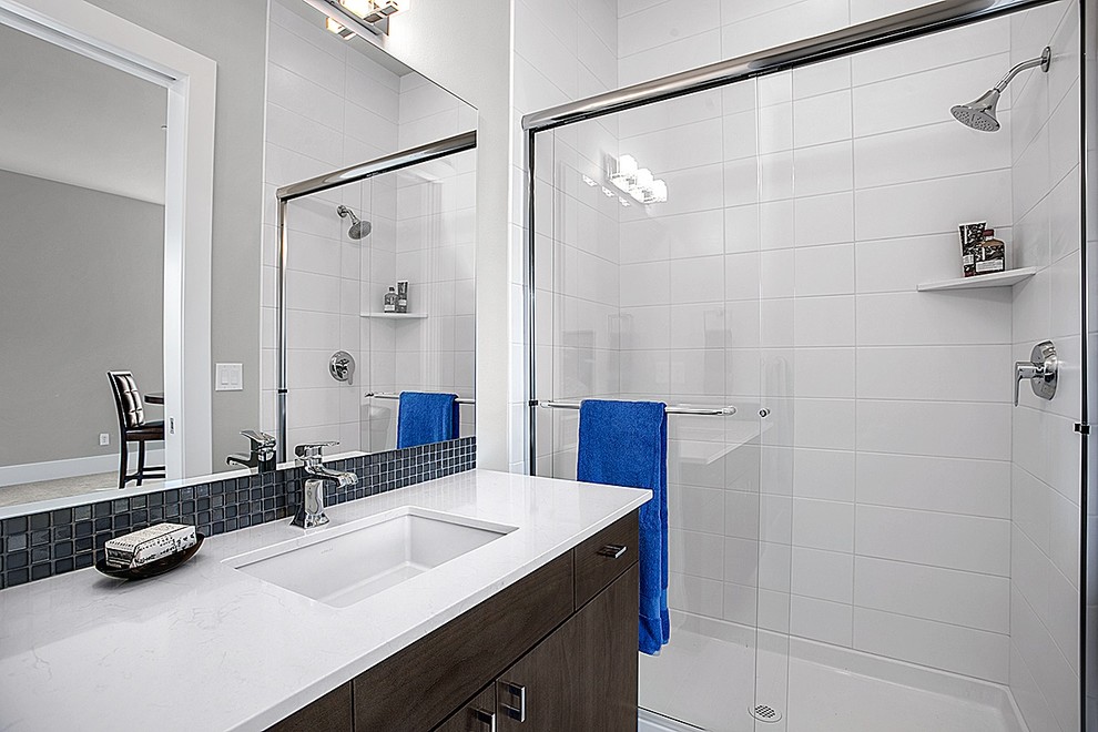 Ispirazione per una stanza da bagno con doccia minimal di medie dimensioni con lavabo sottopiano, ante in stile shaker, ante in legno bruno, piastrelle grigie e pareti grigie