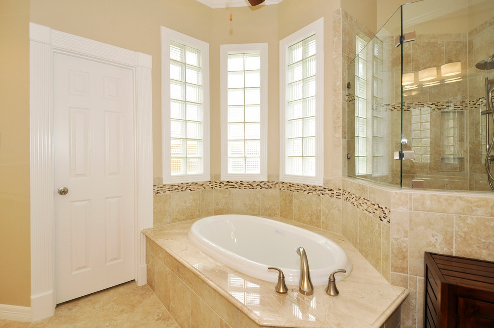 Exemple d'une grande douche en alcôve principale chic avec un lavabo encastré, un placard avec porte à panneau surélevé, des portes de placard blanches, une baignoire posée, WC à poser, un carrelage beige et un mur beige.