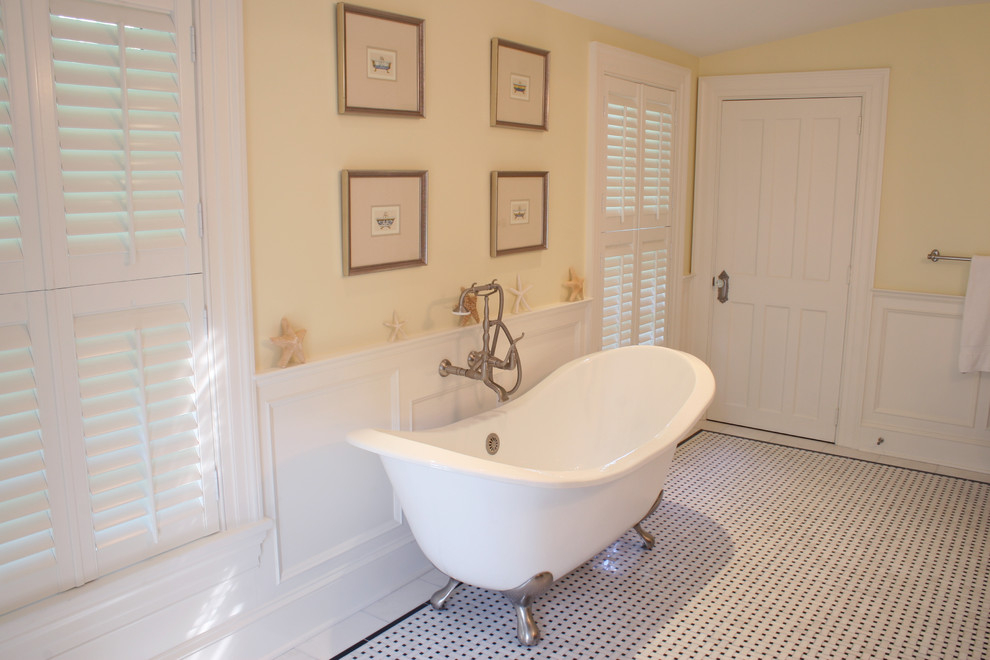 На фото: главная ванная комната среднего размера в стиле кантри с врезной раковиной, ванной на ножках, душем в нише, белой плиткой, желтыми стенами и полом из керамической плитки с