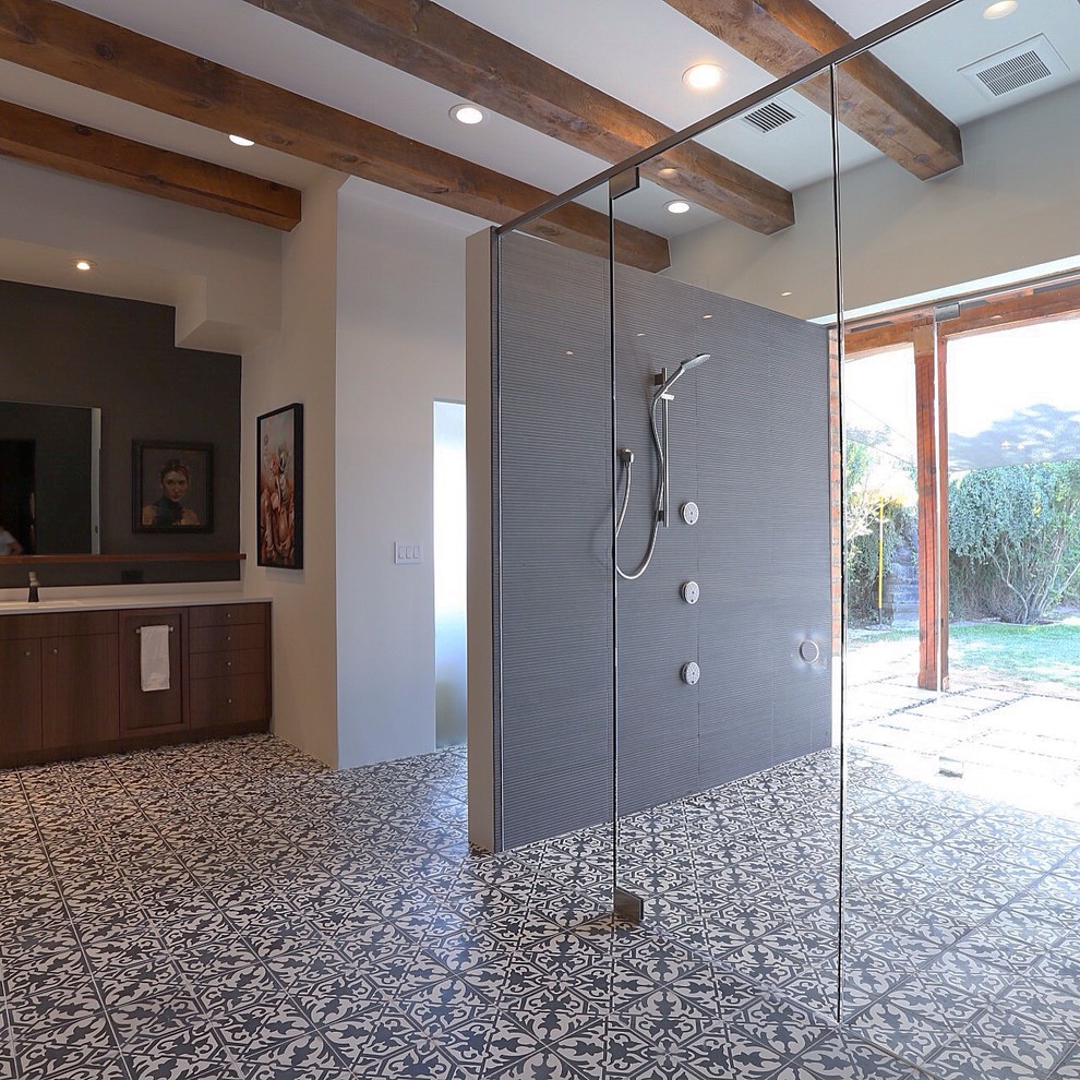 Modern inredning av ett stort en-suite badrum, med släta luckor, skåp i mellenmörkt trä, en kantlös dusch, cementkakel, vita väggar, cementgolv, ett undermonterad handfat, bänkskiva i akrylsten, flerfärgat golv och dusch med gångjärnsdörr