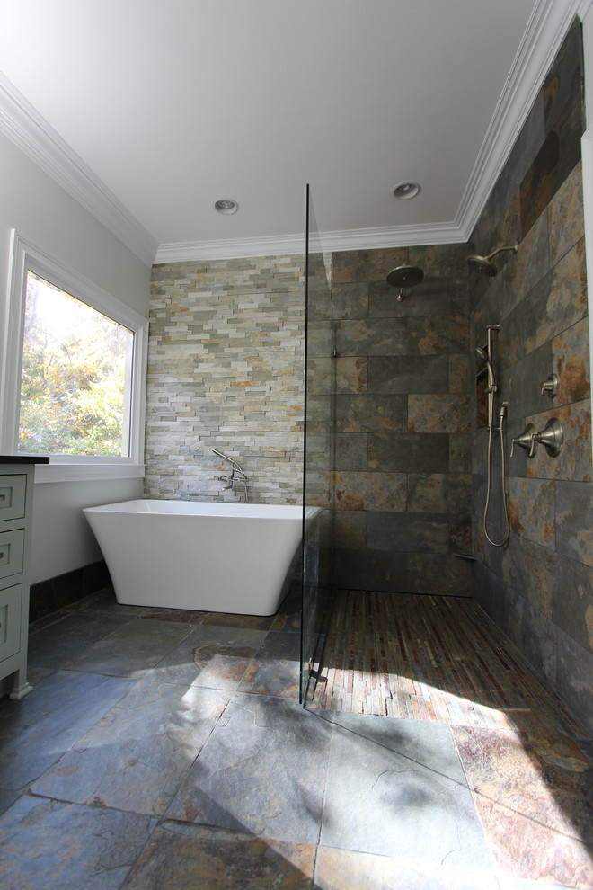 Inspiration for a medium sized bohemian ensuite bathroom in Atlanta with a submerged sink, flat-panel cabinets, green cabinets, granite worktops, a freestanding bath, a built-in shower, a two-piece toilet, multi-coloured tiles, stone tiles, grey walls and slate flooring.