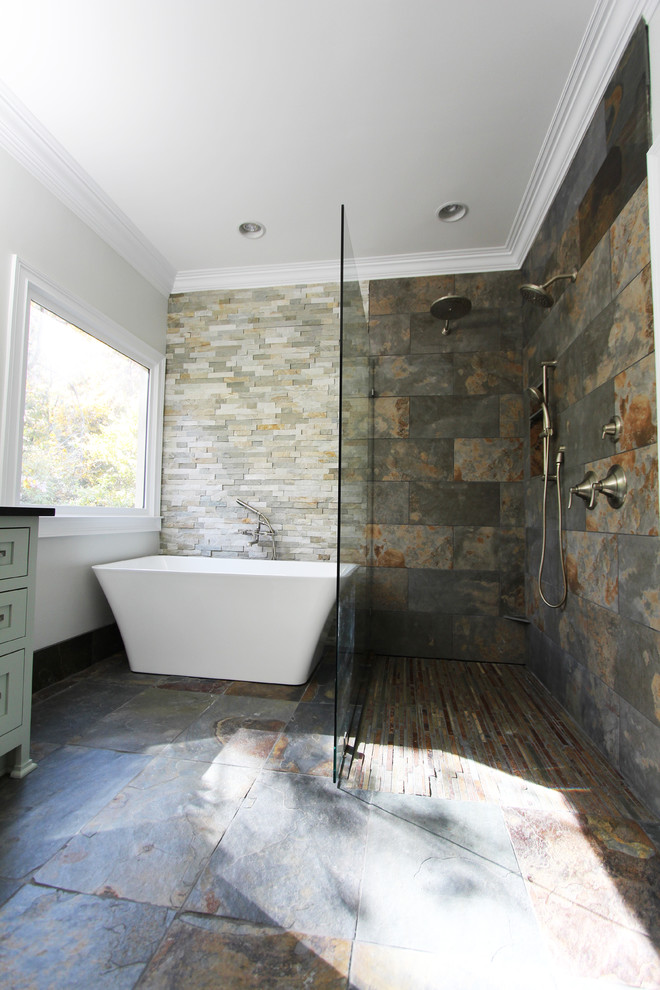 Medium sized eclectic ensuite bathroom in Atlanta with a submerged sink, flat-panel cabinets, green cabinets, granite worktops, a freestanding bath, a built-in shower, a two-piece toilet, multi-coloured tiles, stone tiles, grey walls and slate flooring.