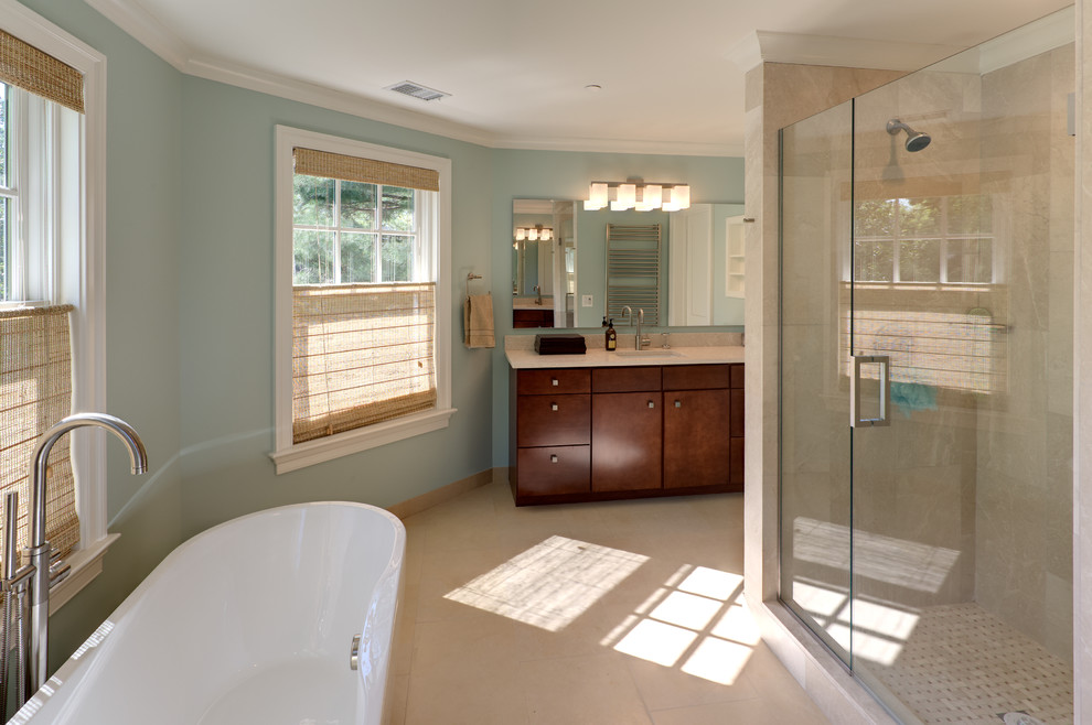 This is an example of a classic bathroom in DC Metro with a submerged sink, medium wood cabinets, a freestanding bath, an alcove shower, beige tiles and blue walls.