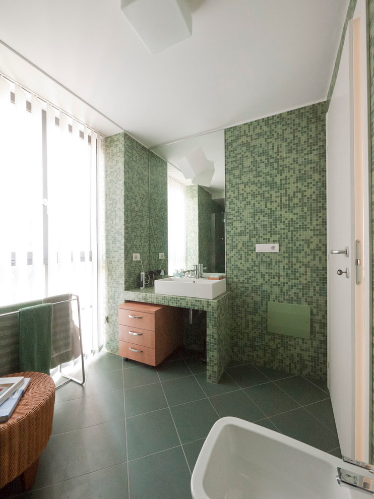 Photo of a small modern ensuite bathroom in Milan with a console sink, tiled worktops, an alcove shower, green tiles, mosaic tiles, green walls, ceramic flooring and medium wood cabinets.