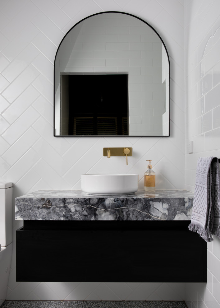Exempel på ett modernt grå grått badrum, med keramikplattor, marmorbänkskiva, släta luckor, svarta skåp, vit kakel och ett fristående handfat
