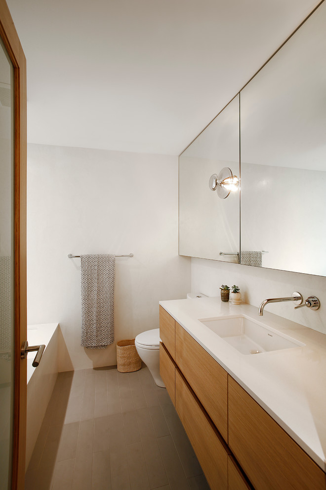 Mittelgroßes Mid-Century Duschbad mit flächenbündigen Schrankfronten, hellbraunen Holzschränken, weißer Wandfarbe, Korkboden, integriertem Waschbecken und Quarzit-Waschtisch in Seattle