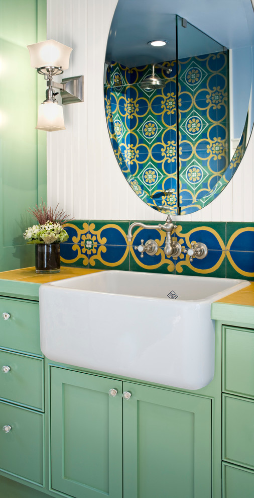 Bild på ett litet eklektiskt badrum med dusch, med gröna skåp, kaklad bänkskiva, ett avlångt handfat, en hörndusch, en toalettstol med hel cisternkåpa, flerfärgad kakel, cementkakel, vita väggar, ljust trägolv, skåp i shakerstil och dusch med gångjärnsdörr