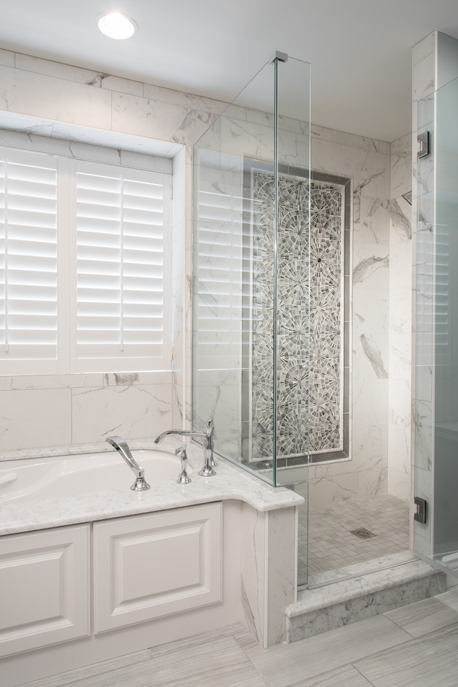 This is an example of a large traditional ensuite bathroom in St Louis with raised-panel cabinets, white cabinets, a submerged bath, a corner shower, white tiles, marble tiles, white walls, porcelain flooring, a trough sink, engineered stone worktops, grey floors and a hinged door.
