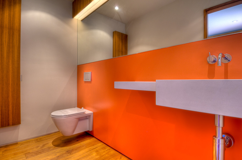 Inspiration for a modern bathroom remodel in Los Angeles with a wall-mount sink, a wall-mount toilet and orange walls