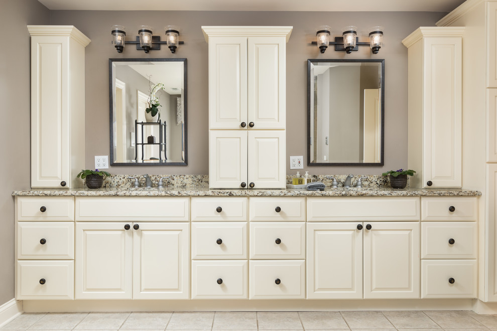 Example of a mid-sized transitional master beige tile and ceramic tile ceramic tile and gray floor drop-in bathtub design in Chicago with raised-panel cabinets, white cabinets, gray walls, an undermount sink and granite countertops