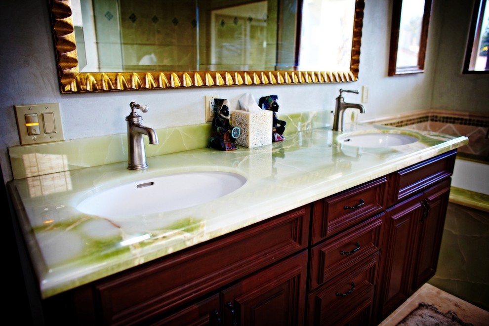 Esempio di una stanza da bagno padronale tradizionale di medie dimensioni con ante a filo, ante in legno bruno, vasca sottopiano, pareti grigie, lavabo sottopiano, top in onice e top verde