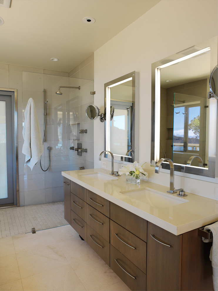 Medium sized contemporary ensuite bathroom in San Francisco with a built-in shower, a submerged sink, engineered stone worktops, grey tiles, glass tiles, beige walls, limestone flooring, flat-panel cabinets, dark wood cabinets and a freestanding bath.