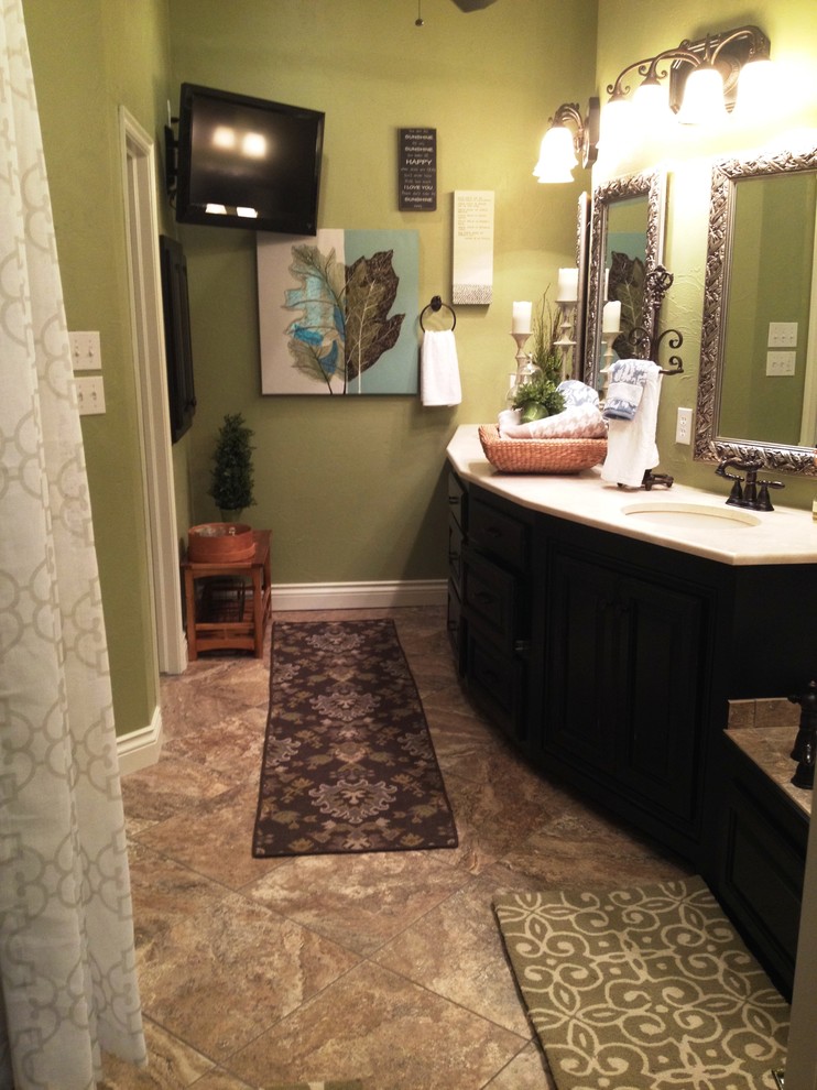 Immagine di una stanza da bagno padronale classica di medie dimensioni con lavabo sottopiano, ante con bugna sagomata, ante nere, top in marmo, piastrelle beige, pareti verdi e pavimento con piastrelle in ceramica