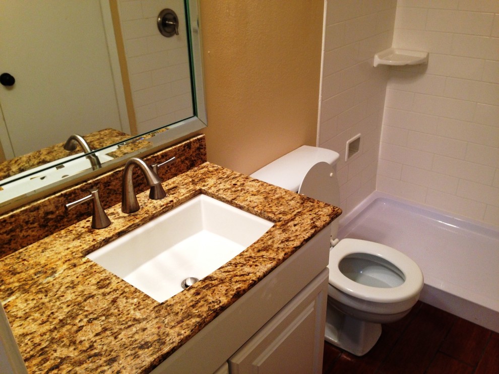Idéer för små funkis badrum med dusch, med luckor med upphöjd panel, vita skåp, en dusch i en alkov, en toalettstol med separat cisternkåpa, vit kakel, keramikplattor, beige väggar, mörkt trägolv, ett undermonterad handfat, granitbänkskiva, brunt golv och dusch med duschdraperi