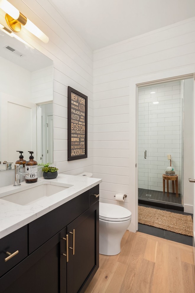 Example of a mid-sized transitional master white tile and subway tile beige floor bathroom design in Seattle with shaker cabinets, white cabinets, white walls, an undermount sink, solid surface countertops, a hinged shower door and gray countertops