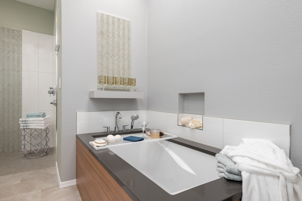 Example of a mid-sized trendy master gray tile and ceramic tile porcelain tile, beige floor and double-sink bathroom design in Other with flat-panel cabinets, medium tone wood cabinets, an undermount tub, a two-piece toilet, gray walls, an undermount sink, quartz countertops, gray countertops and a floating vanity
