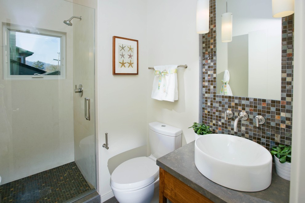 This is an example of a small contemporary shower room bathroom in San Francisco with freestanding cabinets, medium wood cabinets, an alcove shower, a two-piece toilet, multi-coloured tiles, mosaic tiles, white walls, a vessel sink, concrete worktops and a hinged door.