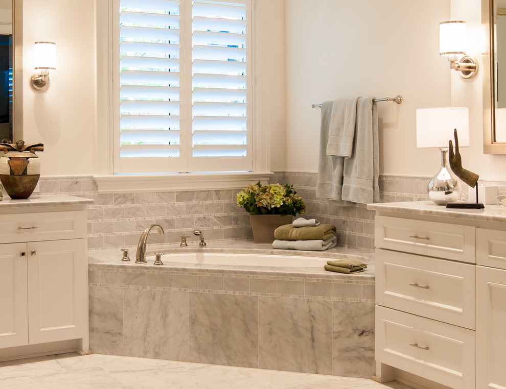 На фото: ванная комната в классическом стиле с врезной раковиной, фасадами с утопленной филенкой, белыми фасадами, мраморной столешницей, душем в нише, серой плиткой, каменной плиткой и полновстраиваемой ванной с
