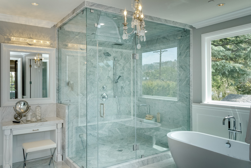 Exemple d'une très grande salle de bain principale chic avec un lavabo intégré, un placard avec porte à panneau encastré, un plan de toilette en marbre, une baignoire indépendante, une douche double, un carrelage blanc, un carrelage de pierre, un mur gris et un sol en marbre.
