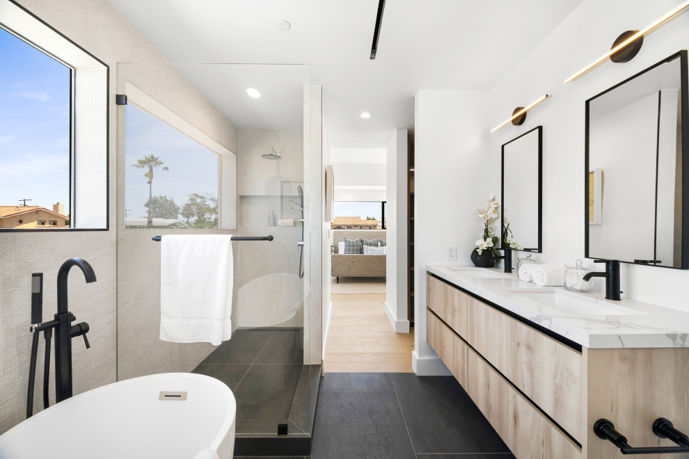 Bathroom - contemporary master double-sink and black floor bathroom idea in Los Angeles with an undermount sink, quartzite countertops, a niche, flat-panel cabinets, light wood cabinets, white walls, white countertops and a floating vanity