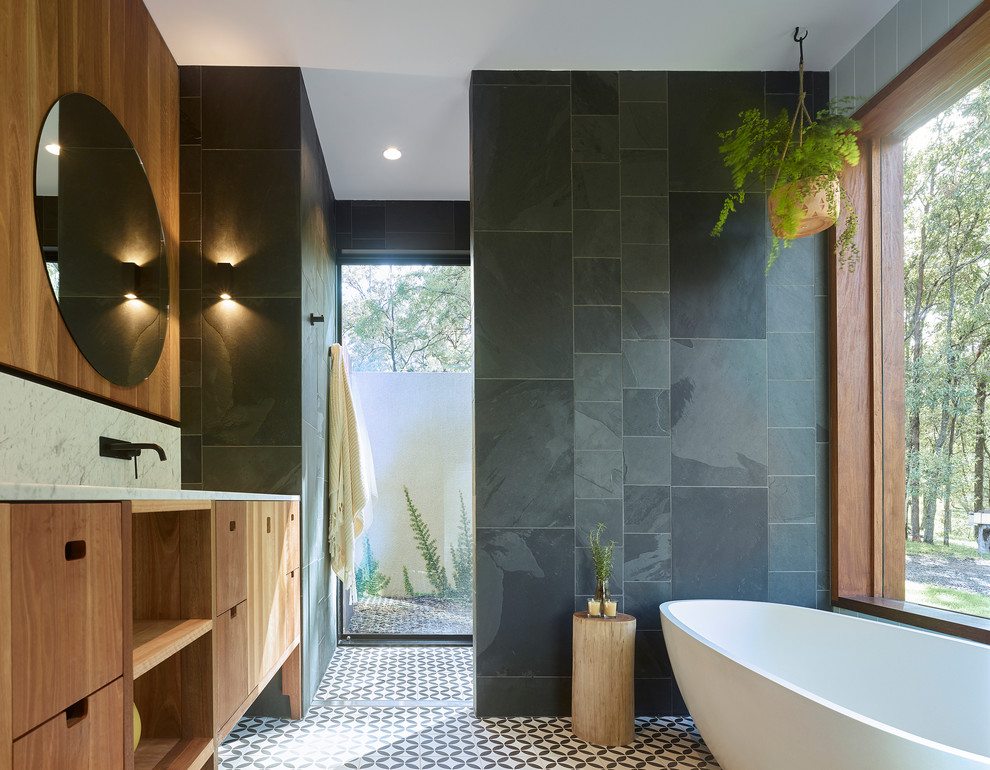 Diseño de cuarto de baño principal contemporáneo con puertas de armario grises, bañera exenta, baldosas y/o azulejos grises y encimera de mármol