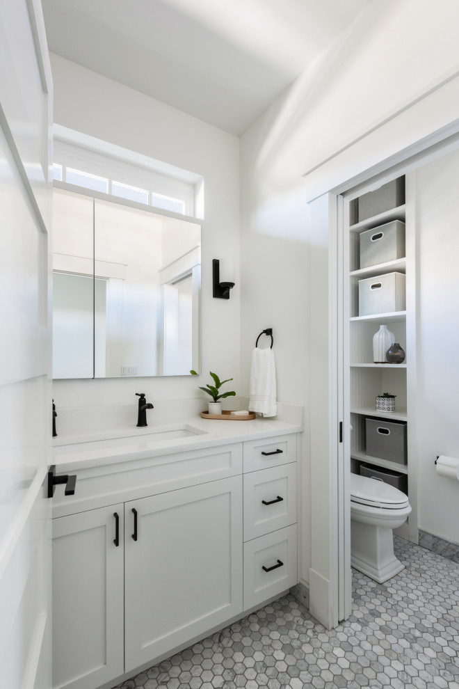 Modelo de cuarto de baño doble y a medida clásico renovado con armarios estilo shaker, puertas de armario blancas, paredes blancas, suelo con mosaicos de baldosas, lavabo bajoencimera, suelo gris, encimeras blancas y cuarto de baño