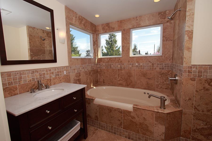 Bathroom - mid-sized traditional master brown tile and porcelain tile porcelain tile and brown floor bathroom idea in Seattle with black cabinets, white walls, an undermount sink, marble countertops, furniture-like cabinets and a one-piece toilet