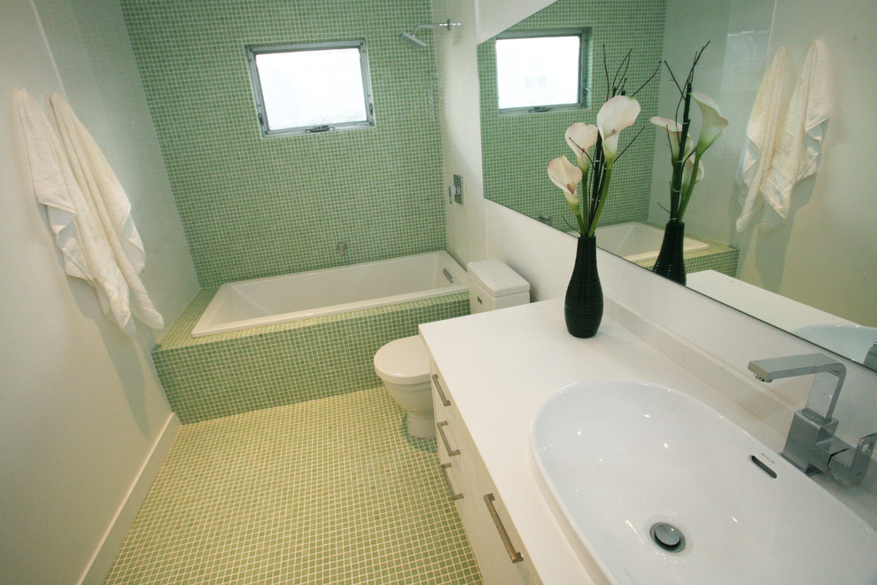 Example of a mid-sized trendy 3/4 green tile and mosaic tile mosaic tile floor and green floor bathroom design in Other with flat-panel cabinets, white cabinets, green walls, a drop-in sink and quartz countertops