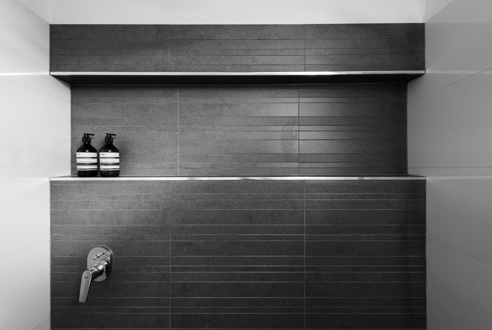 На фото: ванная комната среднего размера в стиле модернизм с серой плиткой, керамогранитной плиткой, белыми стенами, полом из керамогранита, душевой кабиной, плоскими фасадами, темными деревянными фасадами, двойным душем и врезной раковиной
