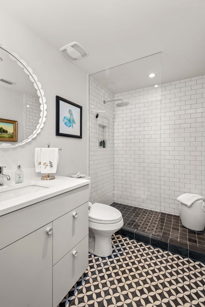 This is an example of a medium sized traditional shower room bathroom in Orlando with flat-panel cabinets, grey cabinets, an alcove shower, a two-piece toilet, white tiles, porcelain tiles, white walls, porcelain flooring, a submerged sink, multi-coloured floors and white worktops.