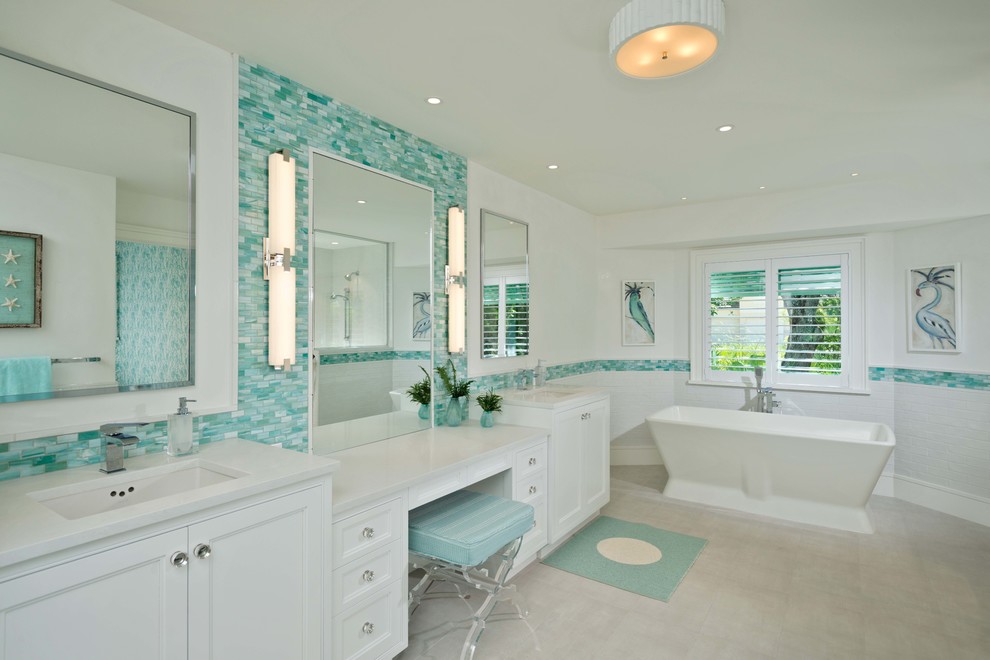 Inspiration pour une salle de bain principale marine avec un placard avec porte à panneau encastré, des portes de placard blanches, une baignoire indépendante, un carrelage vert, mosaïque, un mur blanc, un lavabo encastré, un sol gris et un plan de toilette blanc.