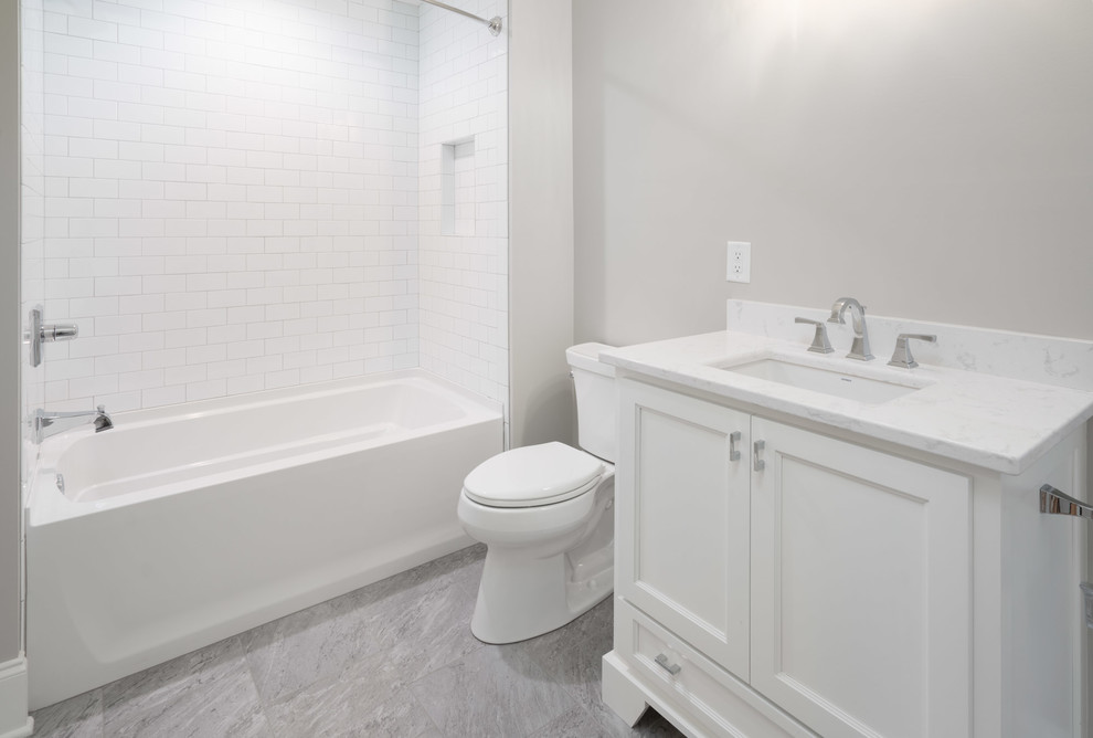 Inredning av ett klassiskt mellanstort badrum med dusch, med skåp i shakerstil, vita skåp, ett badkar i en alkov, en dusch/badkar-kombination, en toalettstol med separat cisternkåpa, vit kakel, tunnelbanekakel, grå väggar, marmorgolv, ett undermonterad handfat, marmorbänkskiva, grått golv och dusch med duschdraperi