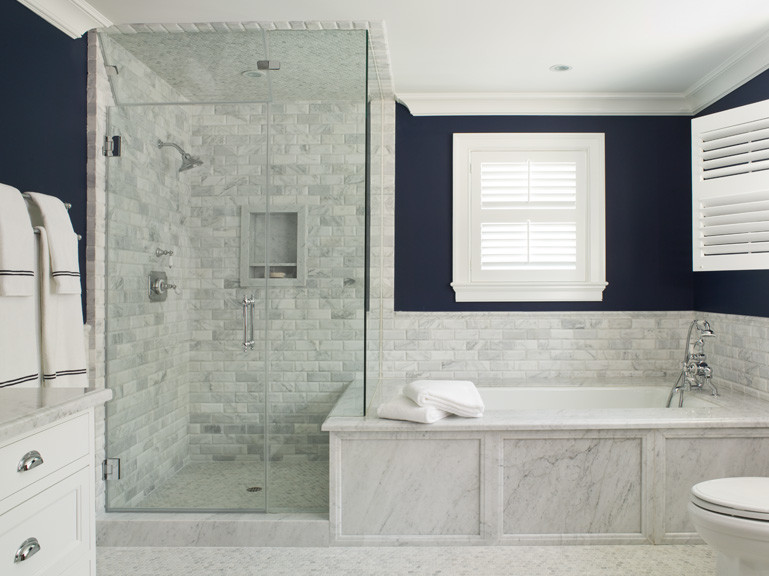 Immagine di una stanza da bagno classica con lavabo sottopiano, ante a filo, ante bianche, top in marmo, vasca sottopiano, doccia ad angolo, WC a due pezzi e piastrelle bianche