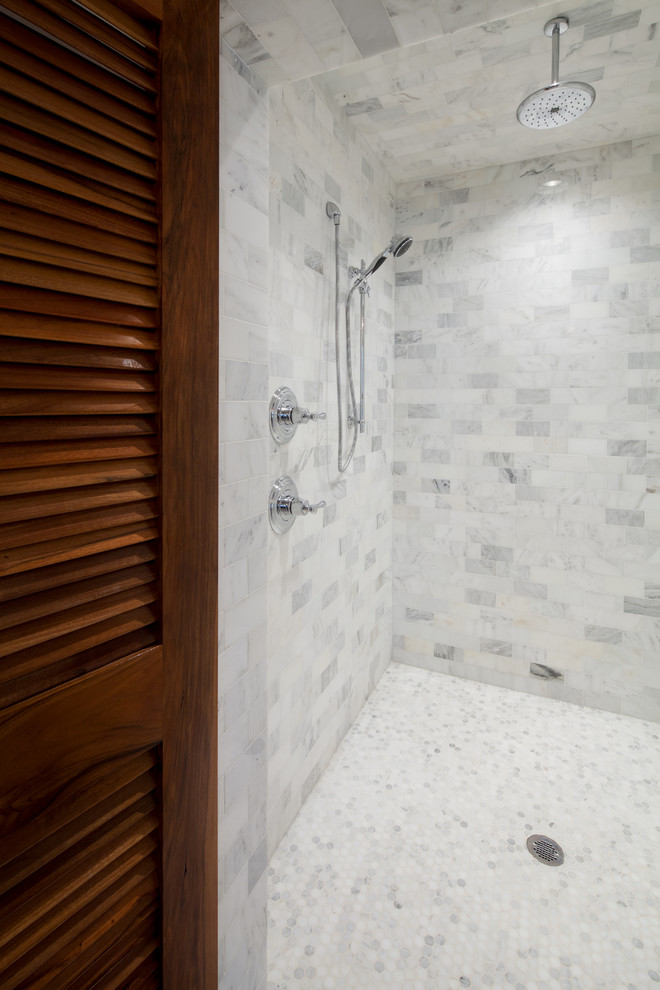 Cette photo montre une salle de bain principale chic avec un lavabo encastré, un placard à porte affleurante, des portes de placard grises, un plan de toilette en marbre, une baignoire indépendante, un carrelage gris, un mur blanc et parquet foncé.