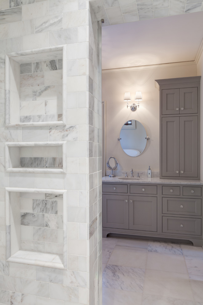 Inspiration for a traditional ensuite bathroom in Charlotte with a submerged sink, beaded cabinets, grey cabinets, marble worktops, a freestanding bath, grey tiles, stone tiles, white walls and marble flooring.