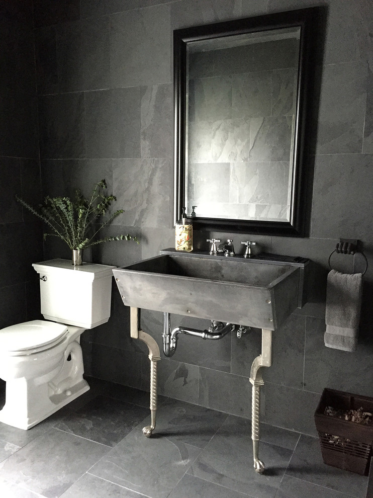 Modelo de cuarto de baño clásico renovado pequeño con ducha esquinera, sanitario de dos piezas, baldosas y/o azulejos negros, baldosas y/o azulejos grises, baldosas y/o azulejos de piedra, paredes negras, aseo y ducha, lavabo tipo consola y suelo de piedra caliza
