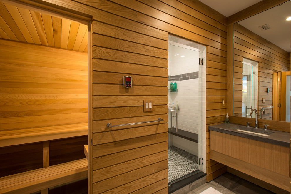 Modelo de sauna clásica con armarios con paneles lisos, puertas de armario de madera oscura, ducha empotrada y lavabo bajoencimera