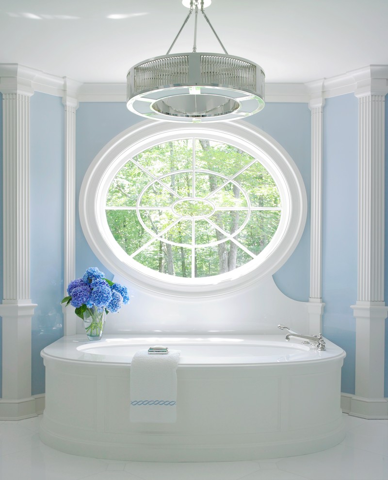 Cette image montre une salle de bain principale marine avec une baignoire encastrée et un mur bleu.